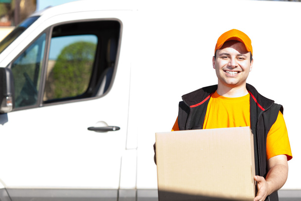 Smiling guy delivering a parcel - Фото, изображение