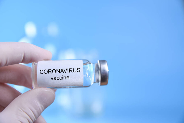 Врач или медсестра с нитрильной перчаткой, держащей коронавирусную вакцину для вакцинации ребенка, медицины и концепции лекарств. - Фото, изображение