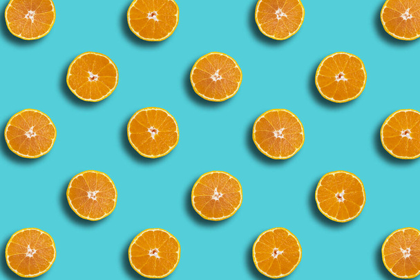 Цветной фруктовый узор сумо мандарин свежие оранжевые ломтики на голубом фоне, весна, летний коцепт
. - Фото, изображение