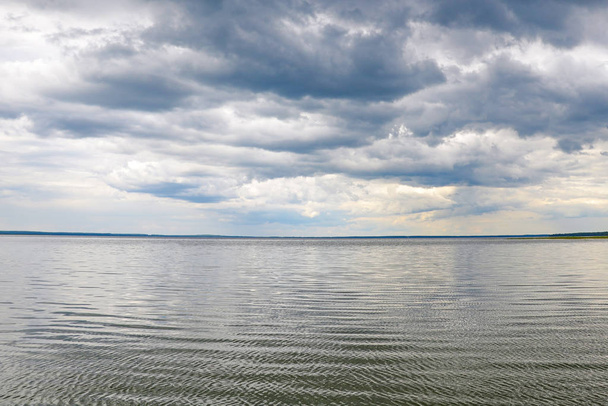 Ακτή μιας μεγάλης λίμνης ή θάλασσας σε μια συννεφιασμένη μέρα - Φωτογραφία, εικόνα