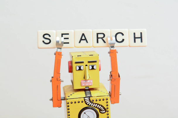 Robot de moteur de recherche est à la recherche de la meilleure métaphore de site Web en ligne avec robot jouet sur carte curuit ordinateur
 - Photo, image