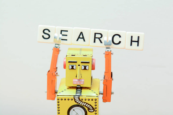 検索エンジンロボットは、コンピュータの回路基板上のおもちゃのロボットと最高のオンラインウェブサイトのメタファーを探しています - 写真・画像