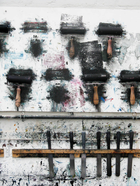 Printrollers hangend aan een kunstatelierwand in de rommelige werkplaats - Foto, afbeelding