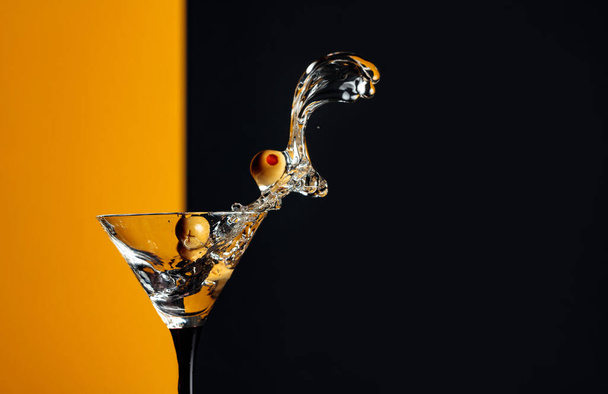 Martini with green olives splash. Copy space. - 写真・画像