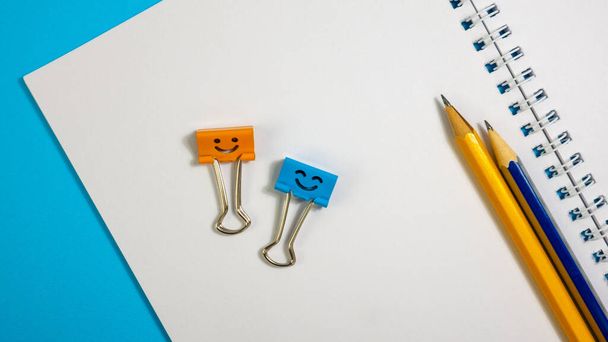 Clip per raccoglitore sorriso con matite sul blocco note
 - Foto, immagini