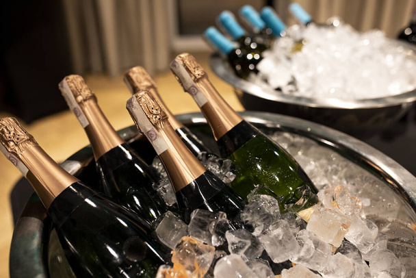 Flaschen Champagner im Kühler. Im Vordergrund Flaschen in Eimern mit Eis. Selektiver Fokus - Foto, Bild