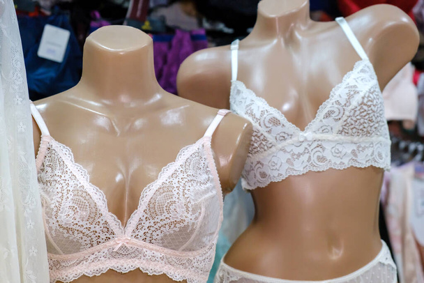 Два манекена, одетые в красивые белые кружева женское нижнее белье в магазине нижнего белья витрина
. - Фото, изображение