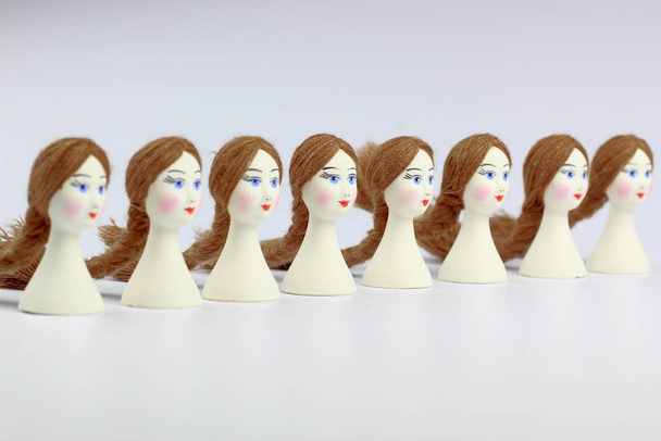 Cabezas de porcelana blanca con una cara pintada para hacer muñecas. Artesanía popular
. - Foto, imagen