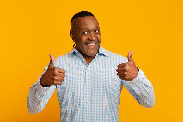 Enthusiastic mature afro american man gesturing thumbs up - 写真・画像