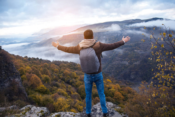 Happy hiker with raised hands in air stand on rock  - Foto, Bild