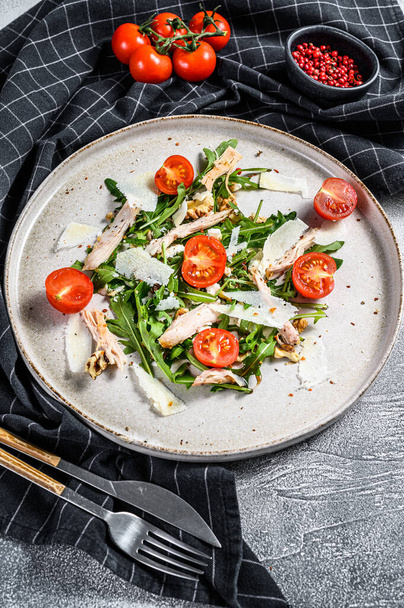 Salad with chicken, arugula, walnuts, tomatoes and Parmesan. gray background. Top view. - Fotoğraf, Görsel