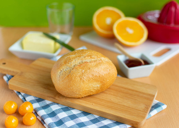 breakfast table with wheat rolls, jam, butter and fruit. On serving boards - Φωτογραφία, εικόνα