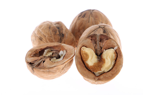 Hele en gebarsten walnoten geïsoleerd op witte achtergrond - Foto, afbeelding