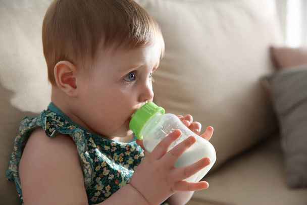 Cute little baby with feeding bottle at home - Photo, Image