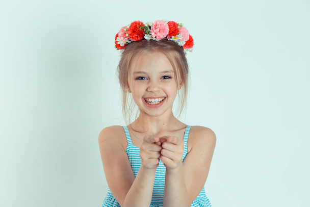 Cute girl kid you pointing fingers looking at you, camera laughing. Closeup portrait of Caucasian kid model with floral headband isolated on white green gray copy space background. Horizontal image. - Фото, зображення