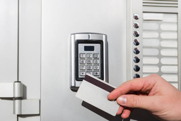 Door access control close up. Man hand holding key card to lock or unlock door. - Foto, imagen