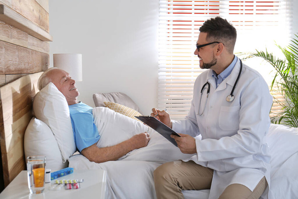 Doctor examining senior patient in modern hospital - Foto, afbeelding