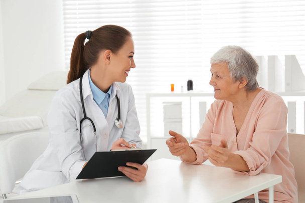 Doctor examining senior patient in modern office - Photo, Image