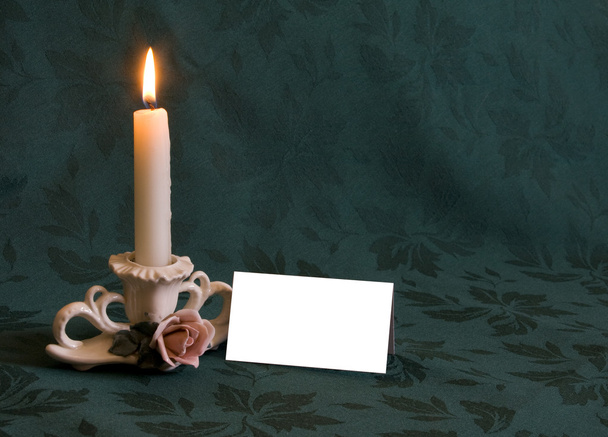 Tarjeta de nota en blanco cerca de Candelabro de porcelana decorativo
 - Foto, Imagen