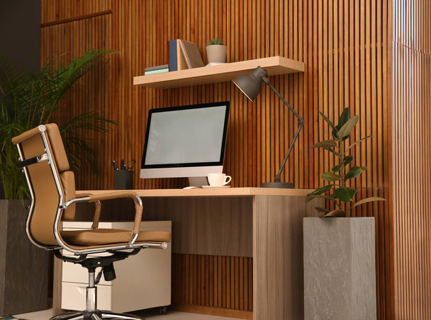 Local de trabalho confortável com computador perto da parede de madeira no interior do quarto elegante. Home office design
 - Foto, Imagem