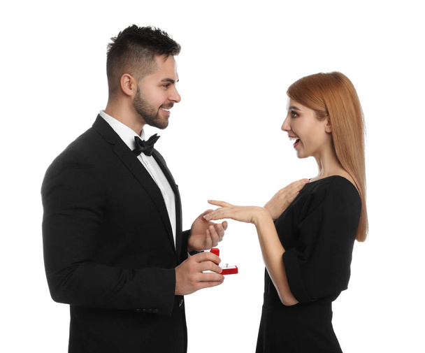 Man with engagement ring making marriage proposal to girlfriend on white background - Фото, зображення