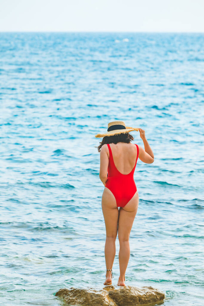 young pretty woman in straw hat at sea beach summer vacation red swimsuit - Valokuva, kuva