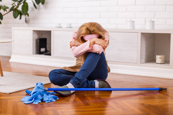 Image of  tired housewife with mop sitting  in the living room. - Foto, Imagen