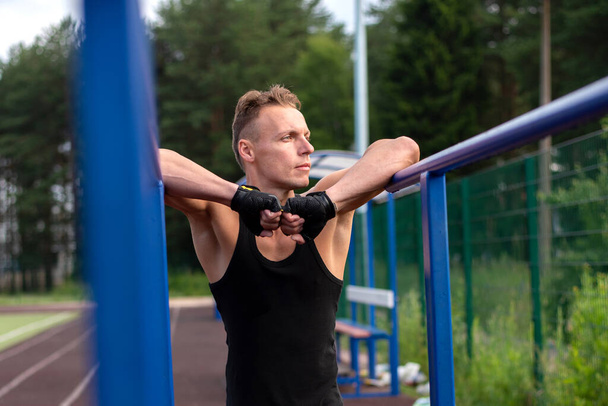 A man is pushing up from parallel bars. For any purpose. - Foto, Bild