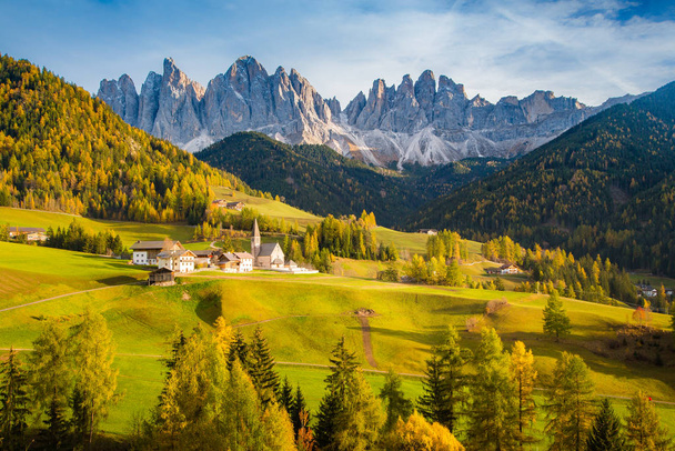Beautiful view of idyllic mountain scenery in the Dolomites with famous Santa Maddelana mountain village in beautiful golden evening light at sunset in fall, Val di Funes, South Tyrol, northern Italy. - Photo, Image