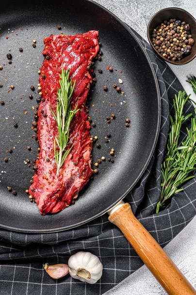 Raw skirt, machete steak in a pan with cooking ingredients. Gray background. Top view. - Foto, imagen