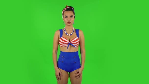 Beautiful girl in a swimsuit is listening attentively and nodding his head pointing finger at viewer. Green screen - Imágenes, Vídeo