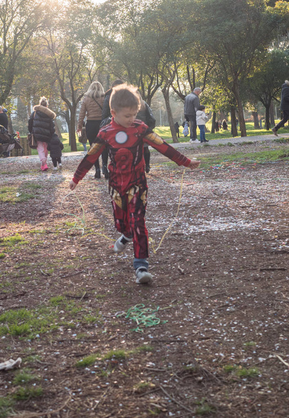Πορτρέτο ενός παιδιού ρίχνει επάνω ένα πολύχρωμο tinsel και κομφετί. Αγόρι γενεθλίων. - Φωτογραφία, εικόνα