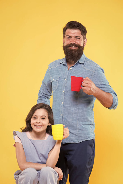Father and daughter drink tea at home. Tea party concept. Good morning. Having coffee together. Water balance and health care. Family drinking tea. Bearded man and happy little girl holding mugs - Zdjęcie, obraz