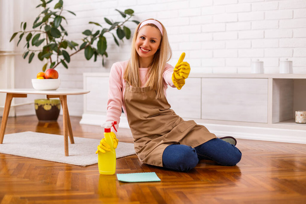 Beautiful housewife enjoys cleaning  her home and showing thumb up. - Fotoğraf, Görsel