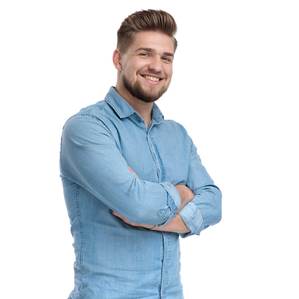 Positive casual man holding his hand crossed and smiling, standing on white studio background - Photo, Image