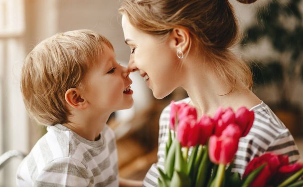 gelukkige mother's Day! kind zoon feliciteert moeder op vakantie en geeft bloem - Foto, afbeelding