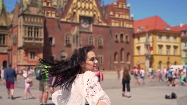 young girl spinning on the central square of the old town. Tourist enjoys summer day walking through the streets of tourist place - Video