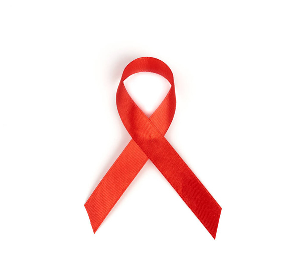 red silk ribbon twisted into a loop.  Symbol of AIDS or HIV awareness isolated on white backgroun - Fotoğraf, Görsel