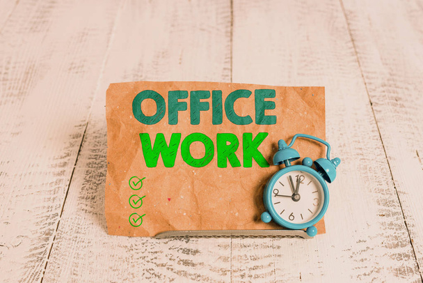 Handwriting text writing Office Work. Concept meaning any clerical or administrative work for an organization Mini blue alarm clock stand tilted above buffer wire in front of notepaper. - Foto, Bild