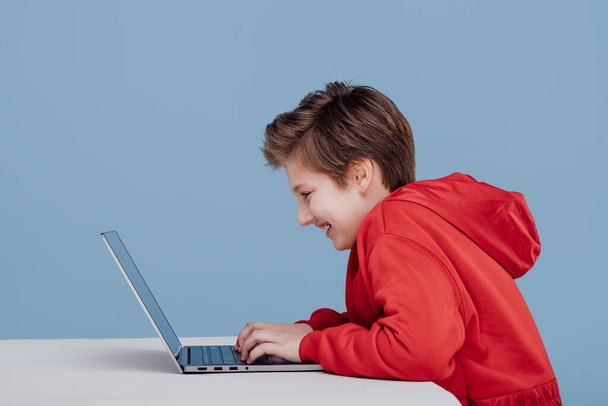 happy boy n red sweatshirt playing on laptop, - Foto, afbeelding
