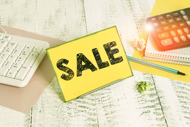 Word writing text Sale. Business concept for event of putting products on high discount Great price Black Friday Notepaper stand on buffer wire in between computer keyboard and math sheets. - Photo, image