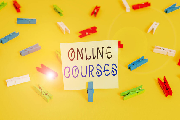Writing note showing Online Courses. Business photo showcasing courses deliver a series of lessons to a web browser Colored clothespin papers empty reminder yellow floor background office. - Photo, Image