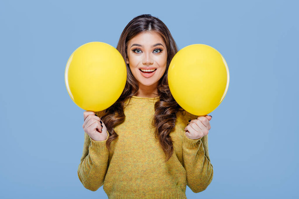 Happy woman with yellow balloons blue background - Foto, Imagem