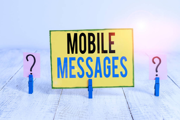 Szövegírás Mobil üzenetek. Üzleti koncepció az elektronikus üzenetek összeállítására és küldésére Írásos és omladozó lap, a fa asztalra helyezett gemkapcsokkal. - Fotó, kép