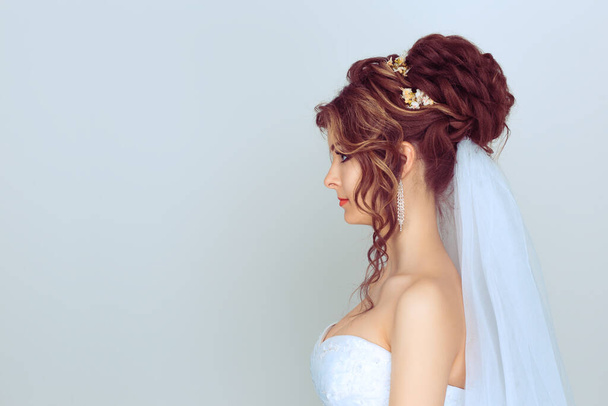 Profile view of Vintage style beauty portrait of a cute brunette bride in veil isolated on light blue background - Φωτογραφία, εικόνα