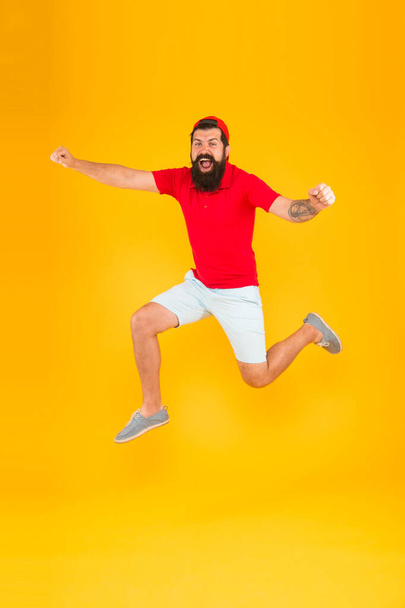 Towards fun. Enjoying active lifestyle. Happy guy jumping. Active bearded man in motion yellow background. Active and energetic hipster. Energy charge. Healthy guy feeling good. Inspired concept - Photo, image