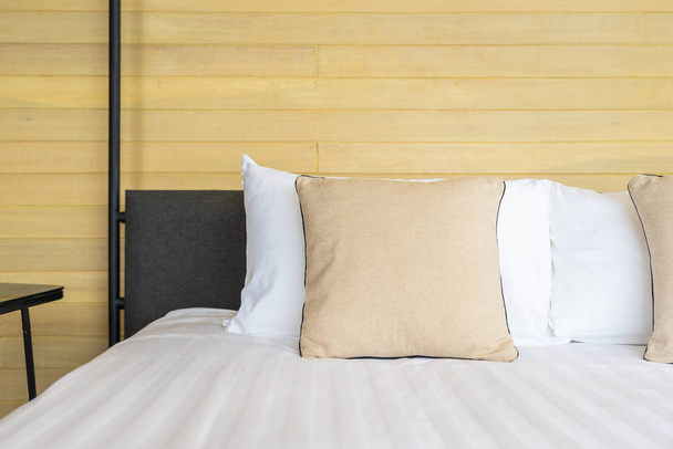 Almohada cómoda blanca en la decoración de la cama interior de la habitación en el complejo hotelero
 - Foto, imagen