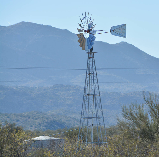 Moinho de vento bombeando água para o tanque de água em Mohave County, Deserto de Sonoran, Arizona EUA
 - Foto, Imagem