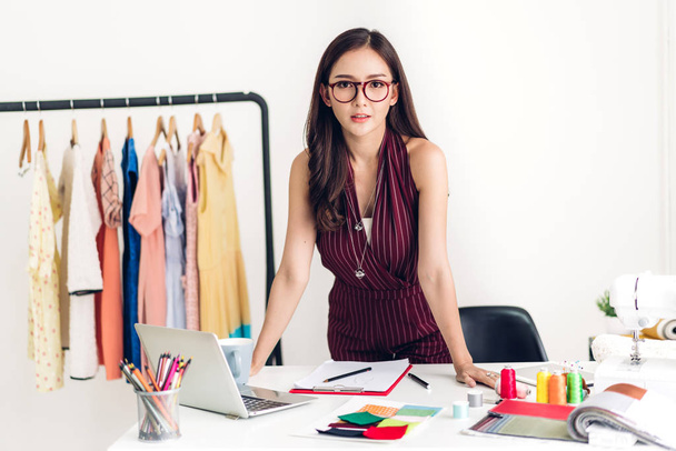 Sorrindo asiática designer de moda mulher trabalhando com computador portátil no estúdio oficina
 - Foto, Imagem