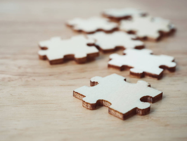 Strategic management and business solutions for success. Jigsaw puzzle connecting on wooden desk - Photo, Image